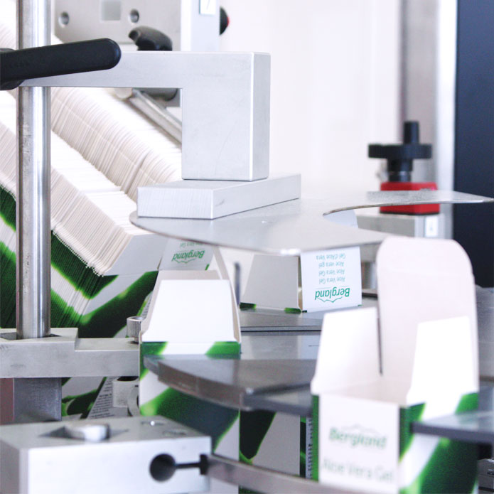 Eine Maschine verschließt Faltschachteln in denen Kosmetik eingepackt wird